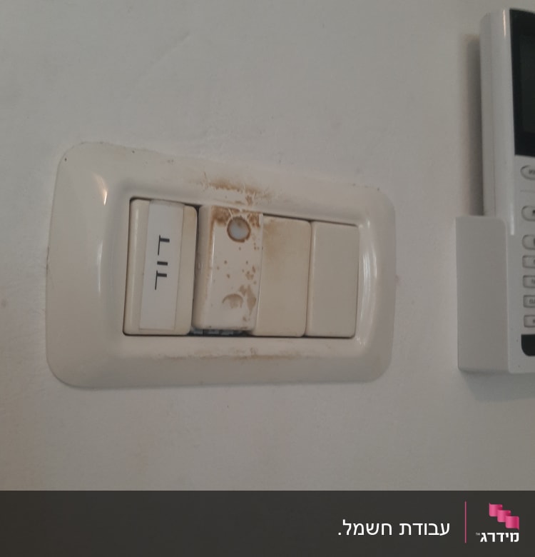 מתגי חשמל מלוכלכים על קיר לבן